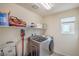 Efficient laundry room with modern washer/dryer, shelving, and natural light from the window at 10031 Fletcher Peak Ave, Las Vegas, NV 89178