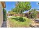 Spacious backyard featuring a grassy lawn, mature trees, and a charming rock border at 1038 Beaver Crest Ter, Henderson, NV 89015