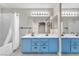Bright bathroom featuring double sinks, modern lighting, and a shower-tub combo at 1038 Beaver Crest Ter, Henderson, NV 89015