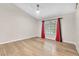 Spacious bedroom with wood floors, neutral walls, ceiling fan, and bright red curtains at 1038 Beaver Crest Ter, Henderson, NV 89015