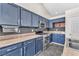 Updated kitchen with stainless steel appliances, blue cabinets, and stylish countertops at 1038 Beaver Crest Ter, Henderson, NV 89015