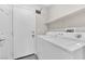 Laundry room features a white washer and dryer, shelving, and a door to the outside at 1038 Beaver Crest Ter, Henderson, NV 89015
