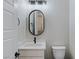 This powder room features an oval mirror, black fixtures, and a modern toilet at 11173 Concord Valley Dr, Las Vegas, NV 89135