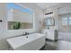 Stylish bathroom featuring a modern soaking tub and view to the mountains out the window at 11173 Concord Valley Dr, Las Vegas, NV 89135