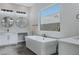 Bright, modern bathroom featuring double sinks, soaking tub, and a large window at 11173 Concord Valley Dr, Las Vegas, NV 89135