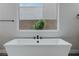 Modern bathtub with a large window, featuring view of exterior wall and foliage at 11173 Concord Valley Dr, Las Vegas, NV 89135