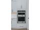 A sleek, stainless steel, double oven nestled within modern white kitchen cabinetry, seamlessly integrated at 11173 Concord Valley Dr, Las Vegas, NV 89135