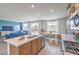 Open kitchen with stainless steel appliances, ample counter space, and an adjacent living area with comfortable blue sofa at 1201 Dre Harbor Pl # Lot 80, North Las Vegas, NV 89084