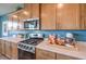 Close-up on a gas range stove top in kitchen with wooden cabinetry and white countertop space at 1201 Dre Harbor Pl # Lot 80, North Las Vegas, NV 89084
