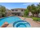 Beautiful backyard featuring in-ground pool and spa, covered patio, and lush greenery at 1312 Fragrant Spruce Ave, Las Vegas, NV 89123
