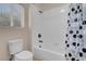 Bright bathroom features a toilet, tub, shower with white tile and polka dot curtain at 1312 Fragrant Spruce Ave, Las Vegas, NV 89123