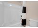 Bright bathroom features a toilet, tub, shower with white tile and black/white curtain at 1312 Fragrant Spruce Ave, Las Vegas, NV 89123
