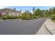 Community entrance featuring a gate, well-maintained landscaping, and paved road at 1312 Fragrant Spruce Ave, Las Vegas, NV 89123