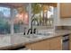 Close up of the kitchen sink and granite countertops by a window with tropical views at 1312 Fragrant Spruce Ave, Las Vegas, NV 89123