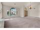 Large living room with arched windows, neutral walls and carpet, offering lots of natural light at 1312 Fragrant Spruce Ave, Las Vegas, NV 89123