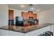 Kitchen featuring sleek granite countertops, black appliances, and wood cabinetry at 1370 Crystal Hill Ln # 3, Henderson, NV 89012