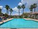 Community pool surrounded by palm trees and lounge chairs at 1370 Crystal Hill Ln # 3, Henderson, NV 89012