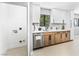 Modern kitchen featuring light cabinets and stainless steel dishwasher, adjacent to a white utility room at 1415 Helen Ave, North Las Vegas, NV 89030