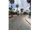 Community entrance featuring palm trees, red rock accents, and paved driveways at 1511 Cardinal Peak Ln # 201, Las Vegas, NV 89144