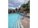 Community pool with seating area, rock landscaping, tiled accents, and a bright blue refreshing swimming pool at 1511 Cardinal Peak Ln # 201, Las Vegas, NV 89144