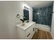Stylish bathroom featuring a sleek vanity, black accents, and modern tiled shower-tub combination at 1600 E Mcdonald Ave, North Las Vegas, NV 89030