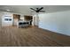 Open-concept living space with new floors, ceiling fan, bright windows, and an adjacent kitchen area at 1600 E Mcdonald Ave, North Las Vegas, NV 89030