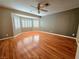 Spacious bedroom features hardwood floors, a ceiling fan, and a bright bay window at 1628 Palmae Way, Las Vegas, NV 89128