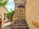 Inviting front porch with a decorative metal gate and tiled steps and walls at 1628 Palmae Way, Las Vegas, NV 89128