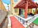 Covered patio area with seating, white balustrade, and red colored wood path at 1628 Palmae Way, Las Vegas, NV 89128