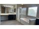 Bright bathroom with a soaking tub, glass enclosed shower, and double sink vanity with wood look flooring at 1777 Gentle Brook St, North Las Vegas, NV 89084