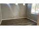 Neutral-toned bedroom featuring wood-look floors, base molding, and a window at 1777 Gentle Brook St, North Las Vegas, NV 89084