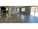 Open-concept living room featuring wood-look floors, neutral walls, and sliding doors to the patio at 1777 Gentle Brook St, North Las Vegas, NV 89084