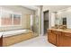 Beautiful bathroom with granite countertops, soaking tub, glass enclosed shower, and tile floors at 2 Lago Turchino Ct, Henderson, NV 89011