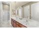 Bathroom featuring double sinks, a large mirror, wooden cabinets, and a glass shower at 2 Lago Turchino Ct, Henderson, NV 89011