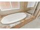 Close-up of the soaking tub in bathroom with granite surround and mosaic tile detail at 2 Lago Turchino Ct, Henderson, NV 89011