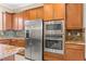 Stainless steel refrigerator and microwave with custom wood cabinetry in the kitchen at 2 Lago Turchino Ct, Henderson, NV 89011