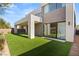 Expansive backyard showcasing lush green artificial turf and the modern architecture of the home at 21 Highland Cove Ln, Henderson, NV 89011