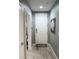 A hallway with a white front door and gray walls, complemented by light wood-look flooring at 23 E Agate Ave # 301, Las Vegas, NV 89123