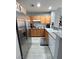A modern kitchen with stainless steel appliances, wood cabinetry, and gray subway tile backsplash at 23 E Agate Ave # 301, Las Vegas, NV 89123