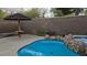 Backyard pool and hot tub with tiki umbrella feature and stone retaining wall at 23 Indian Run Way, Las Vegas, NV 89148