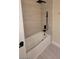 Modern bathroom featuring a tub, a sleek black rain shower head, and neutral-colored walls at 23 Indian Run Way, Las Vegas, NV 89148