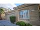 Exterior view of a home featuring a two-car garage and lush landscaping at 23 Indian Run Way, Las Vegas, NV 89148