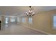 Bright, open-concept living room with elegant chandelier and plantation shutters provides lots of natural light at 23 Indian Run Way, Las Vegas, NV 89148