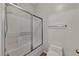 Modern bathroom featuring a glass-enclosed shower-tub and a sleek toilet at 2449 Daks Loden Ct, Henderson, NV 89044