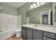 Well-lit bathroom with a tub-shower combo, neutral tile, and dark wood vanity at 2449 Daks Loden Ct, Henderson, NV 89044