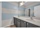 Stylish bathroom with dual sinks and a large mirror reflecting the bright, striped walls at 2449 Daks Loden Ct, Henderson, NV 89044