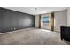 Spacious carpeted bedroom features a chandelier, large window, and stylish curtains at 2449 Daks Loden Ct, Henderson, NV 89044