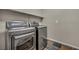 A laundry room featuring modern front load washer and dryer with white shelving at 2449 Daks Loden Ct, Henderson, NV 89044