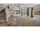 Spacious living room featuring a curved staircase and large windows with custom drapes at 2449 Daks Loden Ct, Henderson, NV 89044