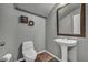 A cozy powder room features a pedestal sink, tile flooring and is freshly painted at 2449 Daks Loden Ct, Henderson, NV 89044